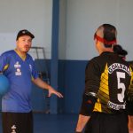 professor Leonardo Goulart, com uma bola embaixo do braço, conversa com alunos de goalball