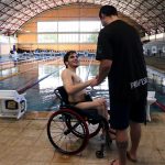 aluno em cadeira de rodas sorri enquanto cumprimenta o professor Julio Pistarini