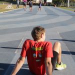 corredor Vinícius Alan Galafassi sentado de costas na pista de Atletismo da UFSC
